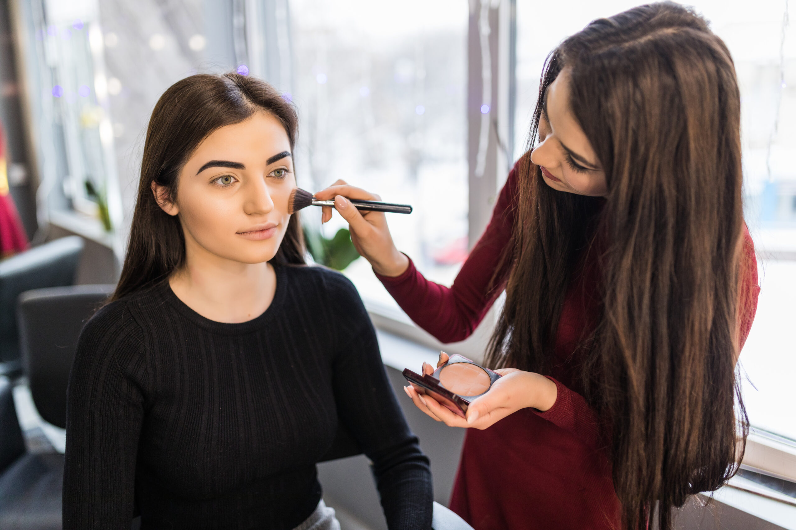 Young model with big eyes is having make-up procedure